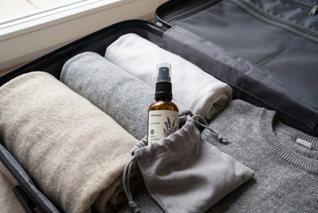 Kissenspray in 30 ml im gepackten Koffer neben gerollter Kleidung