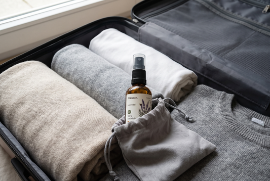 Kissenspray in 30 ml im gepackten Koffer neben gerollter Kleidung